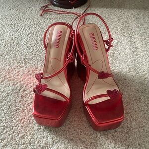 Red 7” heels with hearts and string around the calf.